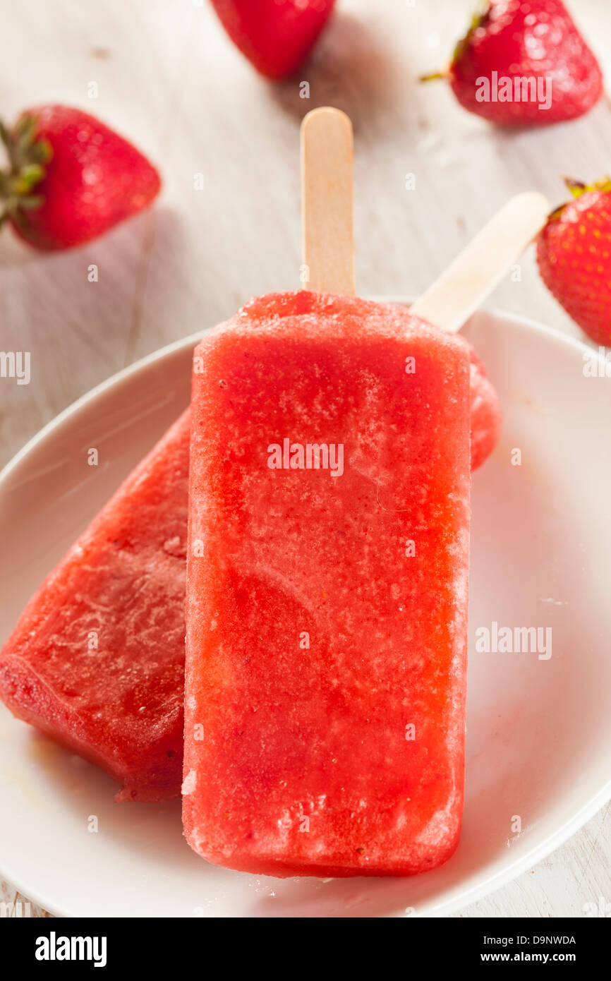 Kalten Bio eingefroren Erdbeere Frucht Eis am Stiel mit einem Stock Stockfoto