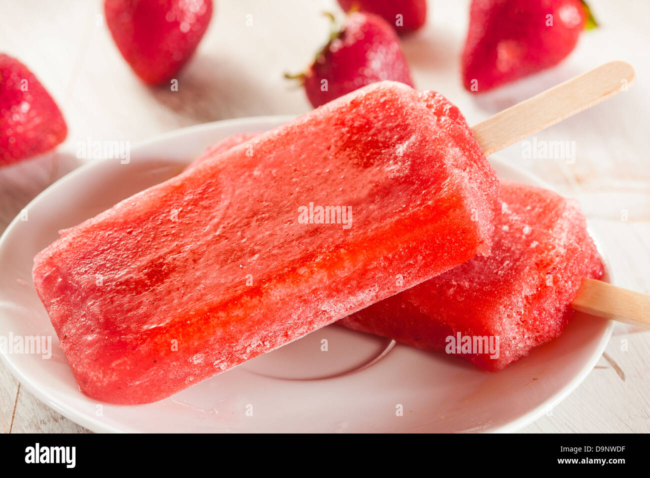 Kalten Bio eingefroren Erdbeere Frucht Eis am Stiel mit einem Stock Stockfoto