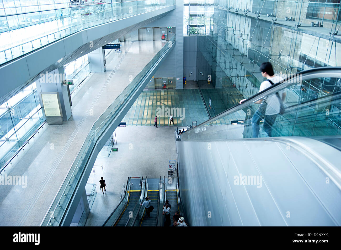 Menschen auf Rolltreppen auf im Singapore Changi International Airport. Stockfoto