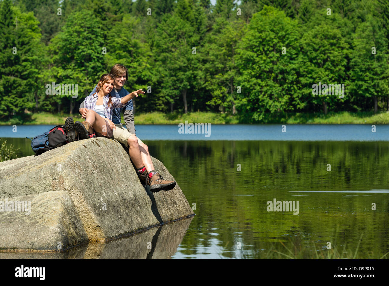 Junge Wanderer paar sitzt auf Felsen am See Stockfoto