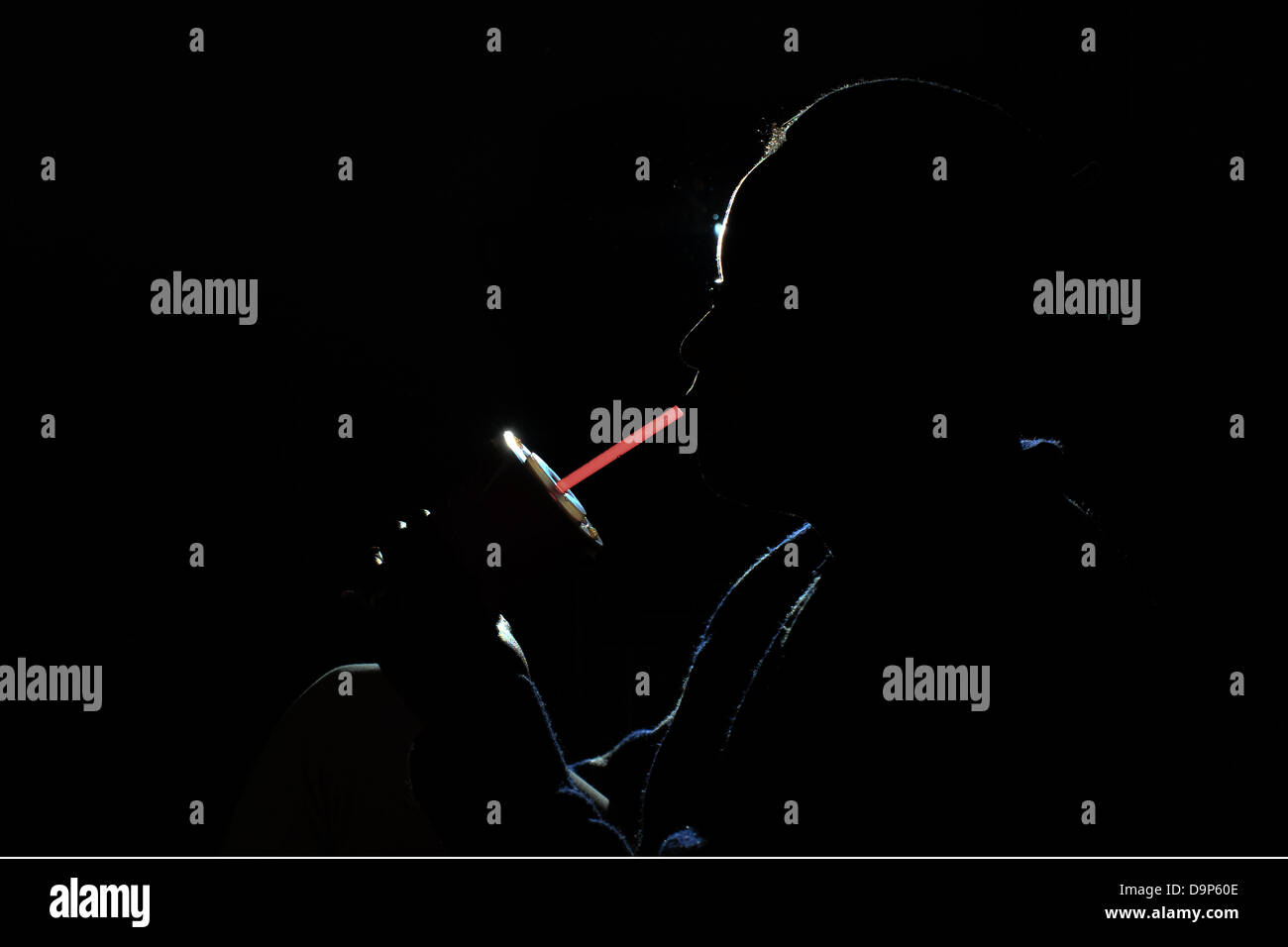 Eine Silhouette einer Frau, die ein Fast-Food-Art Limonade durch einen Strohhalm trinken. Stockfoto