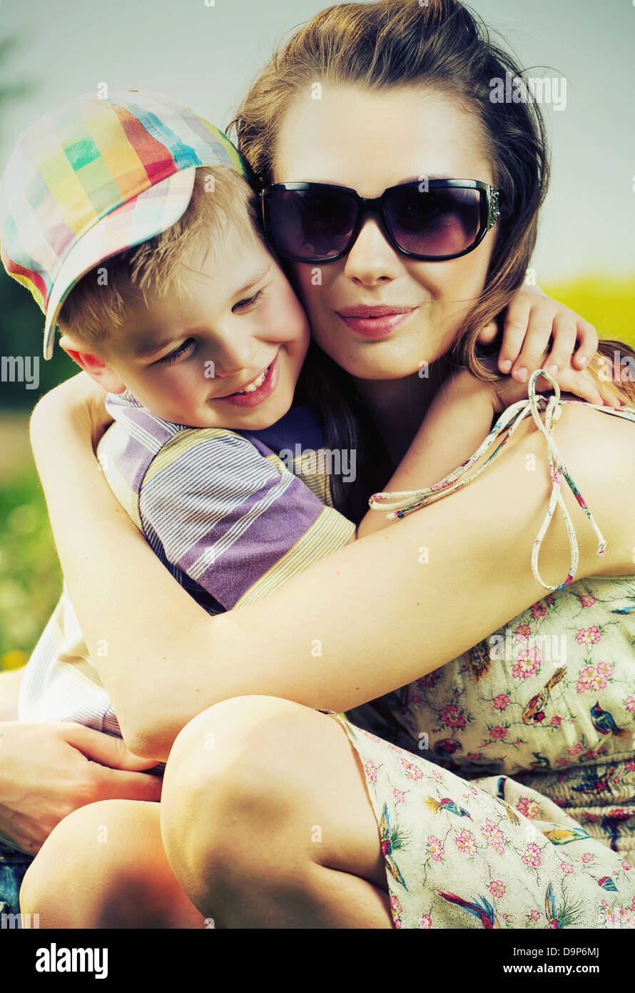 Schöne Mutter umarmt ihren niedlichen kleinen Sohn Stockfoto