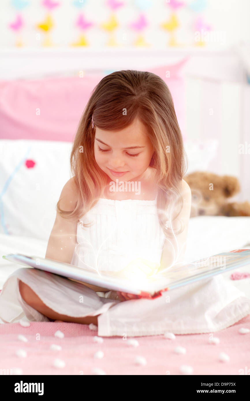 Kleines Mädchen in einem Märchenbuch lesen Stockfoto