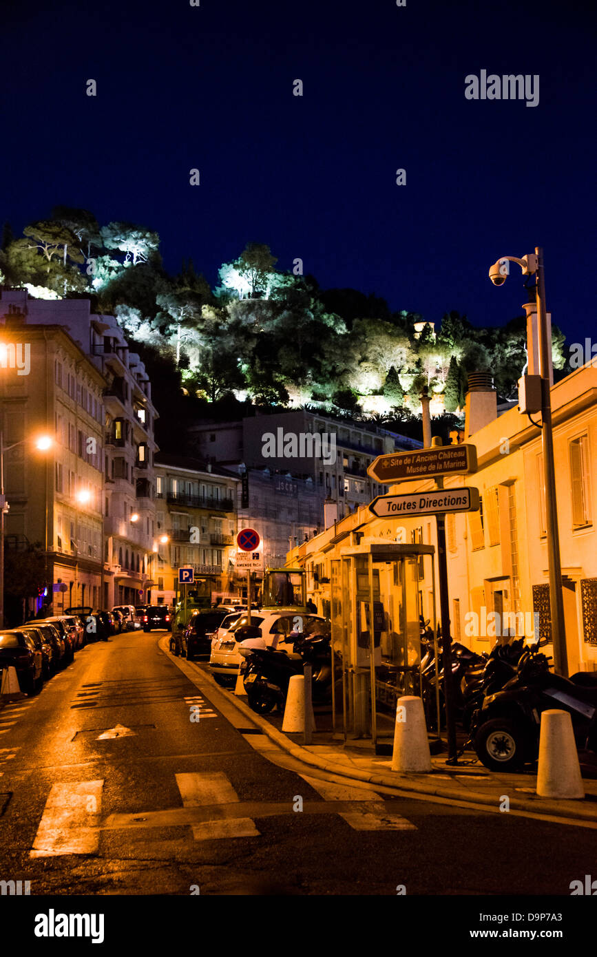 Eine kleine Seitenstraße mit parkenden Autos neben der Promenade des Anglais in die alte Stadt von Nizza Frankreich in der Nacht mit dem Burgberg Stockfoto