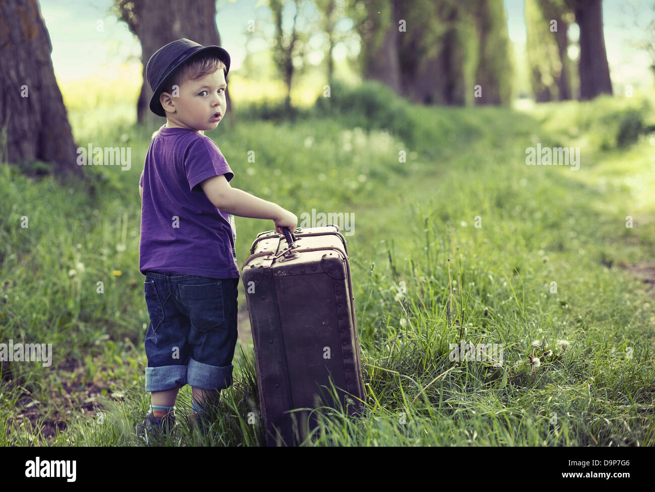 Kleine süße Mann aus dem Haus mit riesigen Gepäck Stockfoto