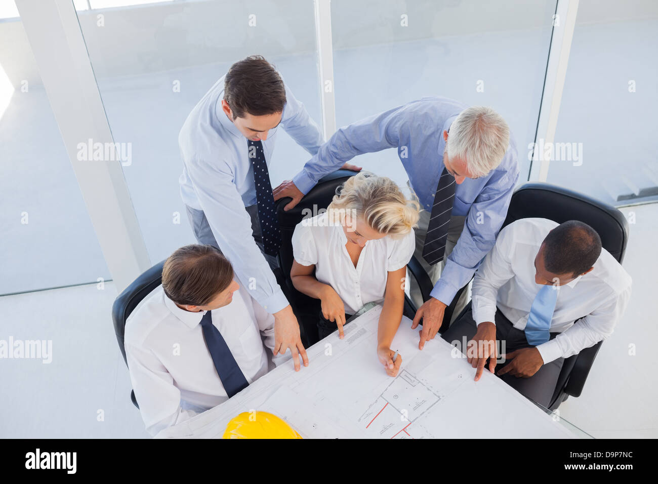Fünf Architekten, die auf Blaupausen Stockfoto