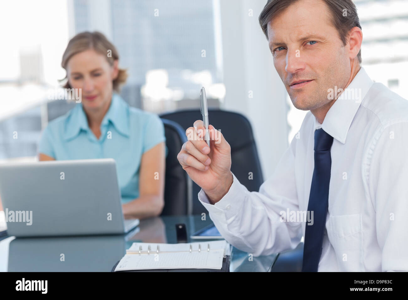 Business-Mann hält einen Stift Stockfoto