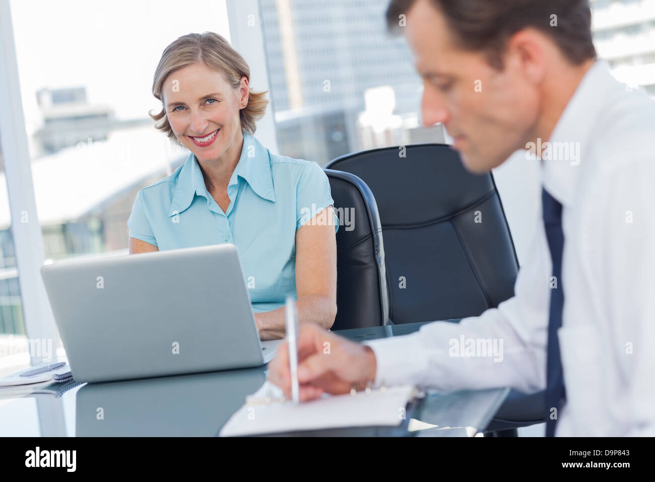 Geschäftsleute, die gemeinsam im selben Büro Stockfoto