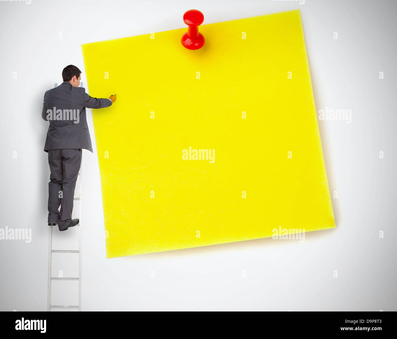Geschäftsmann, stehen auf Leiter auf große gelbe Notiz schreiben Stockfoto