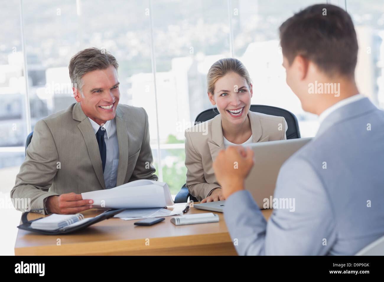 Lächelnde Geschäftsleute lachend mit Antragsteller Stockfoto