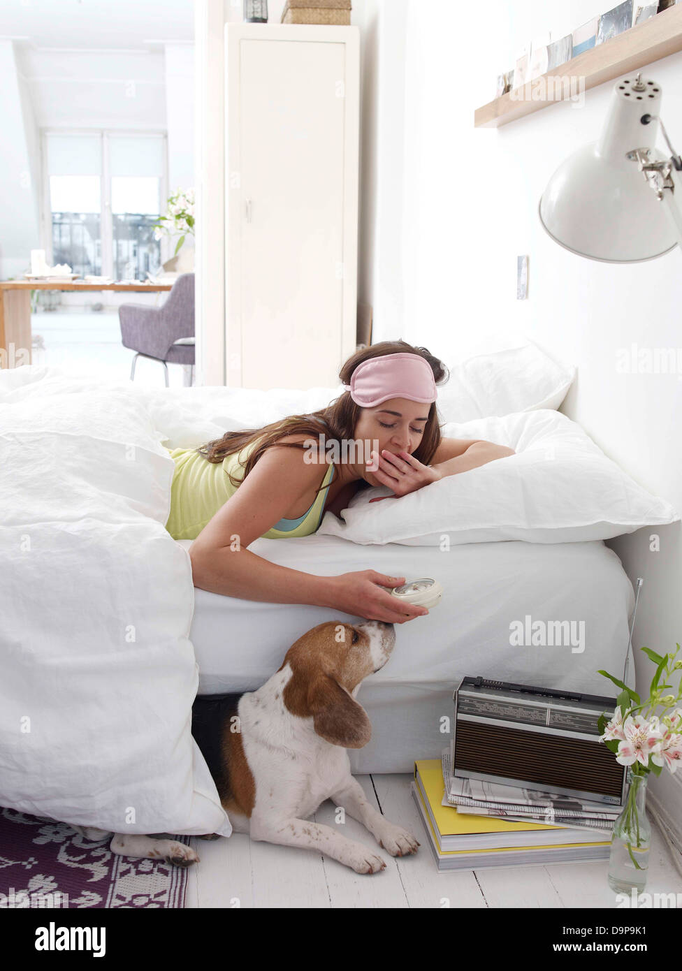 Brünette junge Frau im Bett liegend Stockfoto