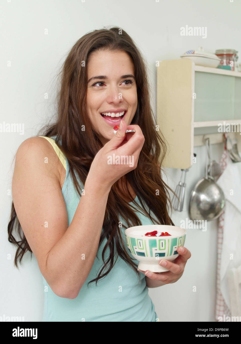 Brünette junge Frau Essen Joghurt mit Erdbeeren Stockfoto