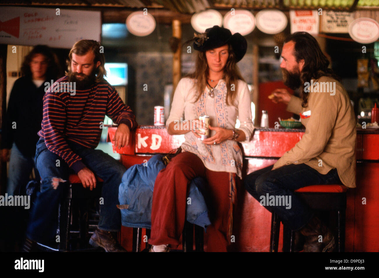 Hippies Hippie Mode Kleidung Menschen reden ein Getränk trinken in einer Bar sitzen auf Barhockern in Mendocino, Nordkalifornien, USA Amerika 1970er Jahre 1977 KATHY DEWITT Stockfoto