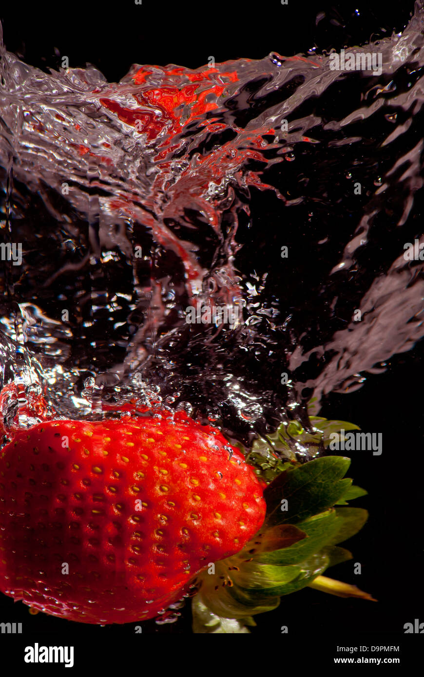 Erdbeere Spritzer ins Wasser Stockfoto