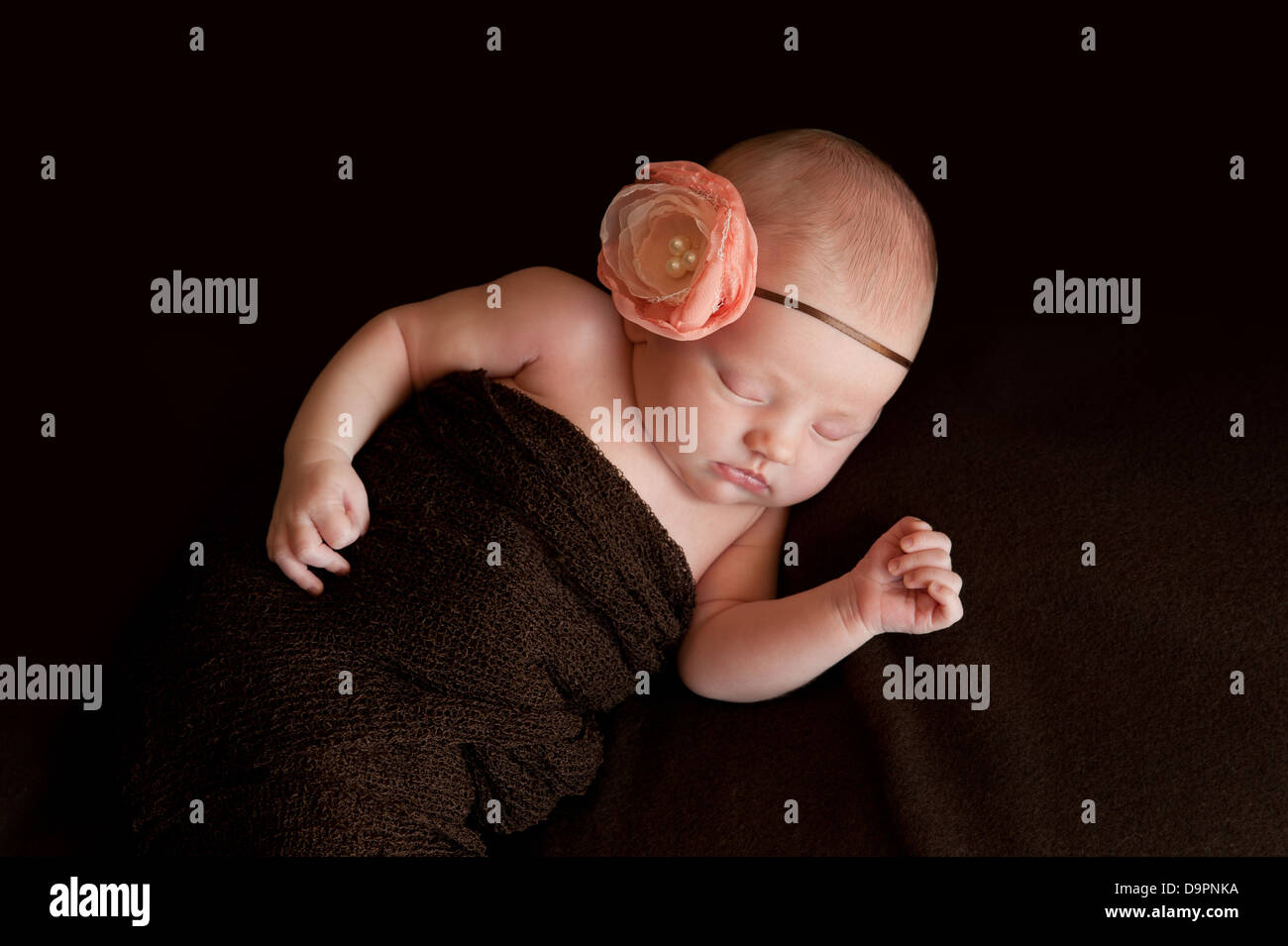 Neugeborenes Mädchen mit Blumen Haarband Stockfoto