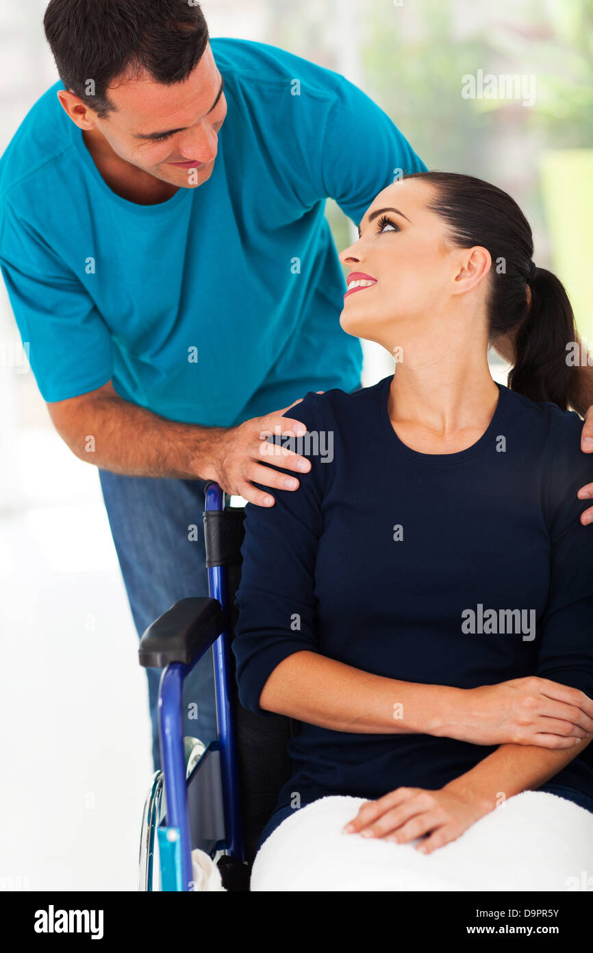 liebevoller Ehemann im Gespräch mit behinderten Frau zu Hause Stockfoto