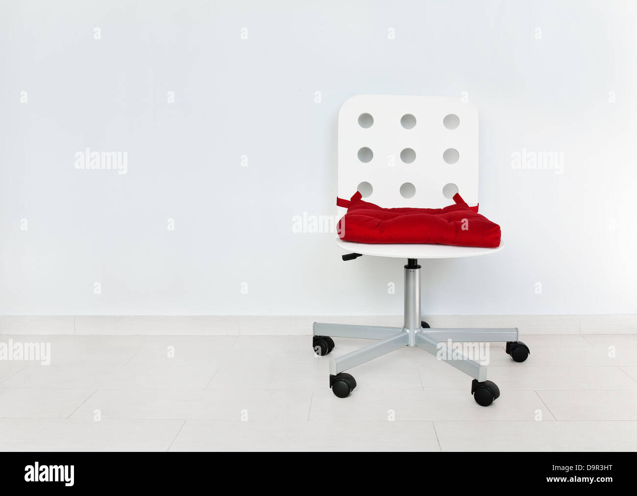 Weißer Stuhl gegen die Wand Stockfoto