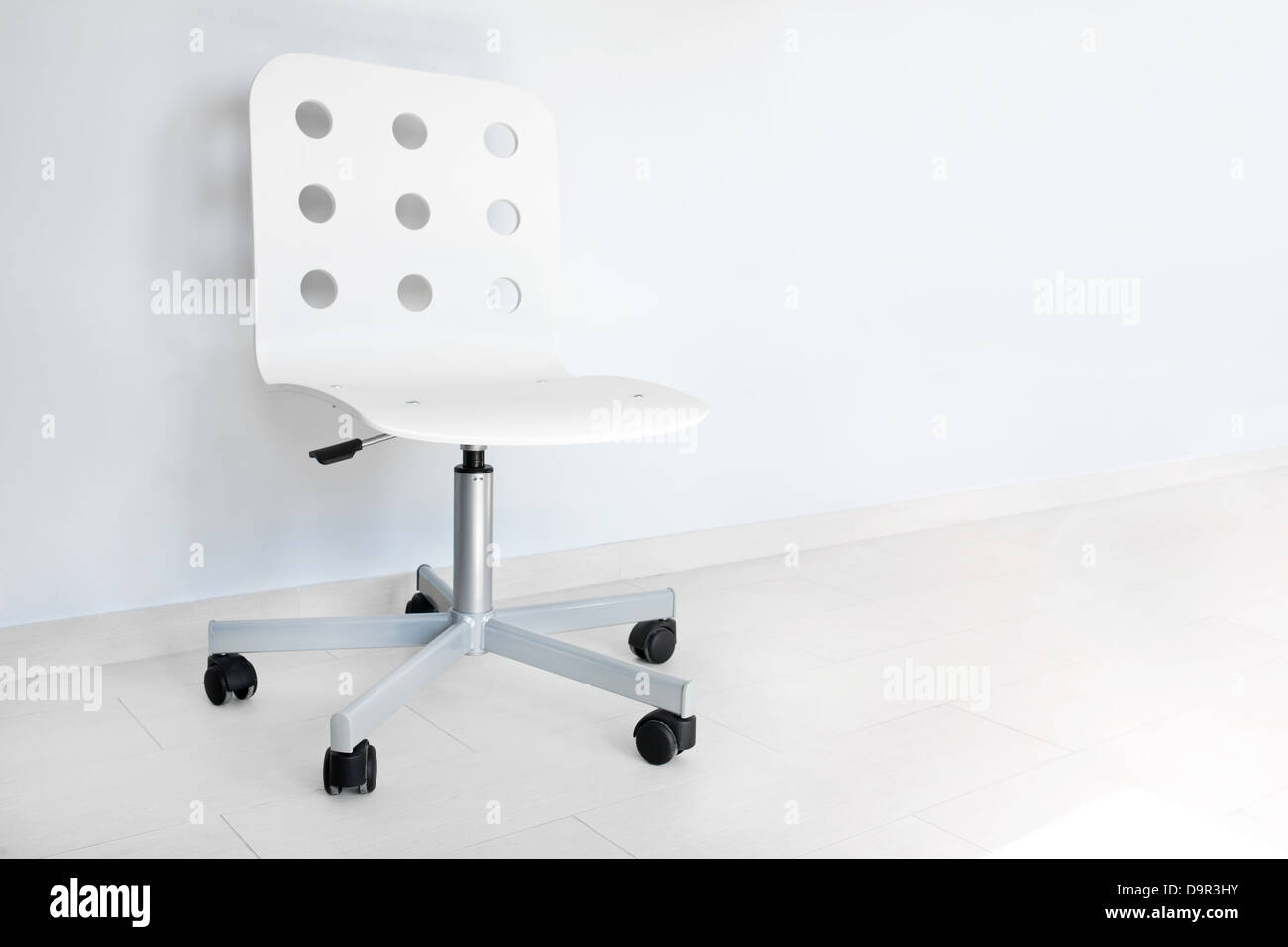 Weißer Stuhl gegen die Wand Stockfoto
