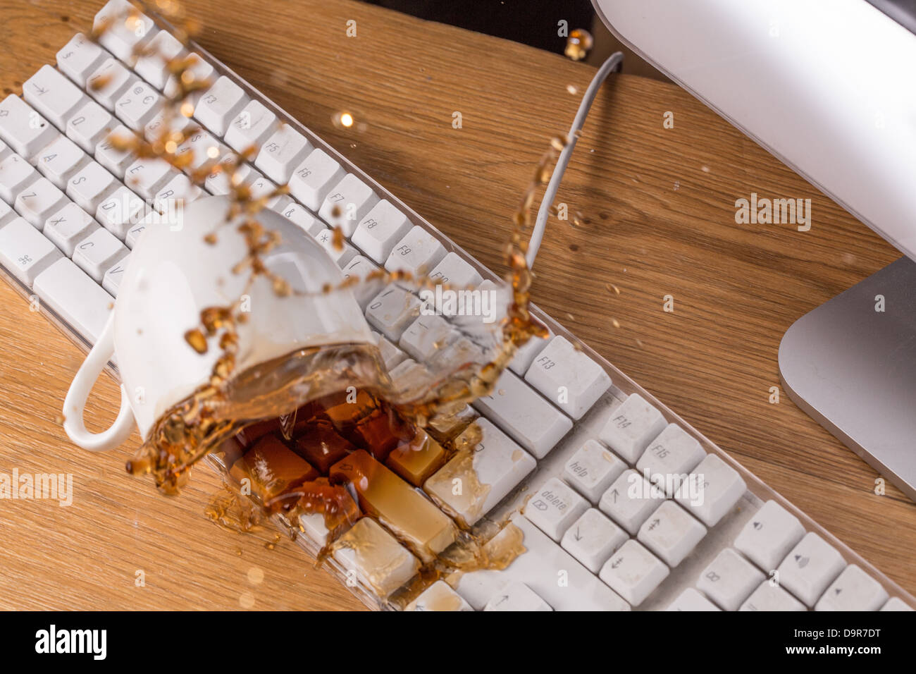 Tasse Tee schwappte über eine Tastatur Stockfoto