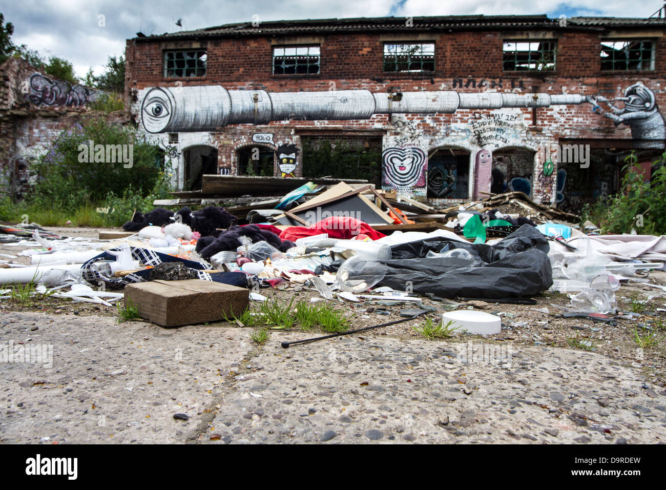 Haufen Müll und eine zerbrochene Weinglas außerhalb eines Graffiti bedeckt einstürzenden Gebäude Stockfoto