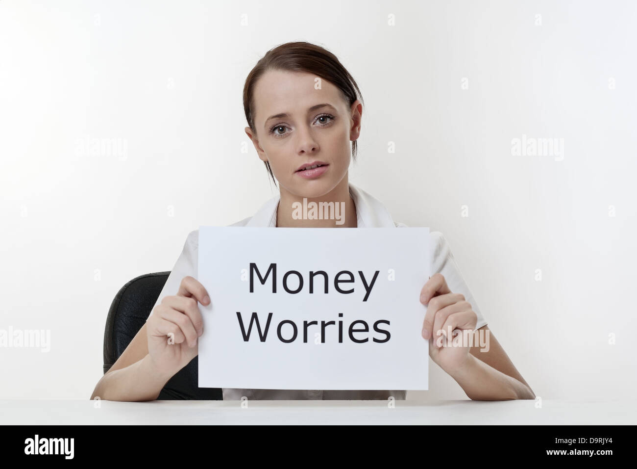 Frau sitzt an einem Schreibtisch besorgt über ihre Geldsorgen Stockfoto