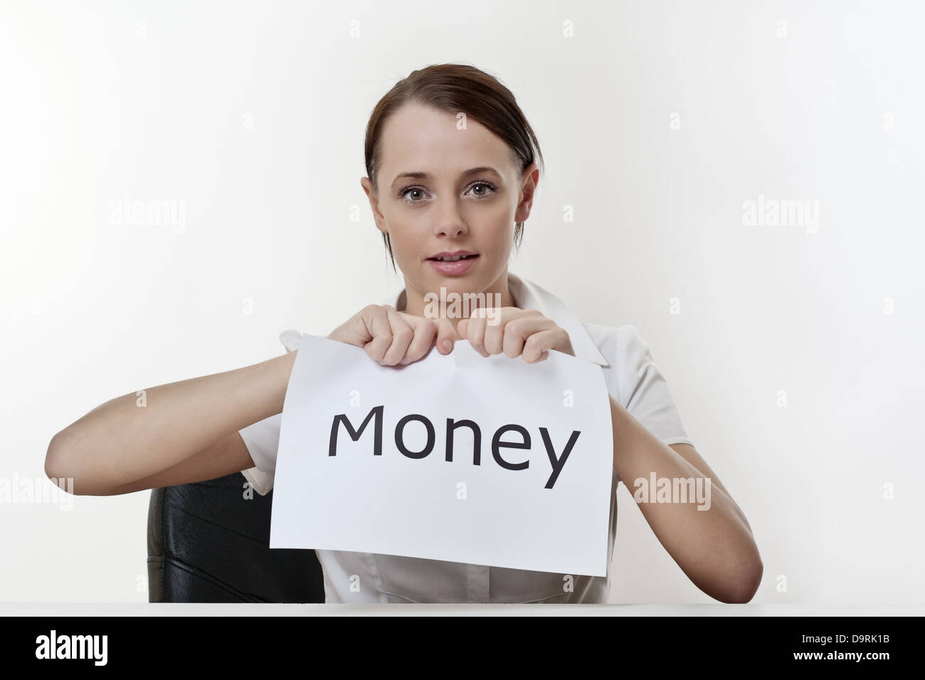 Frau sitzt an einem Schreibtisch, ihre Geldsorgen loszuwerden Stockfoto
