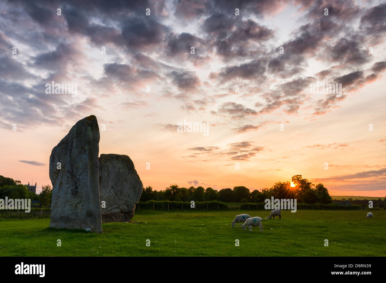 Die Sonne leuchtet der Himmel, wie es hinter den Steinen in Avebury in Wiltshire nur drei Tage nach der Sommersonnenwende. Stockfoto