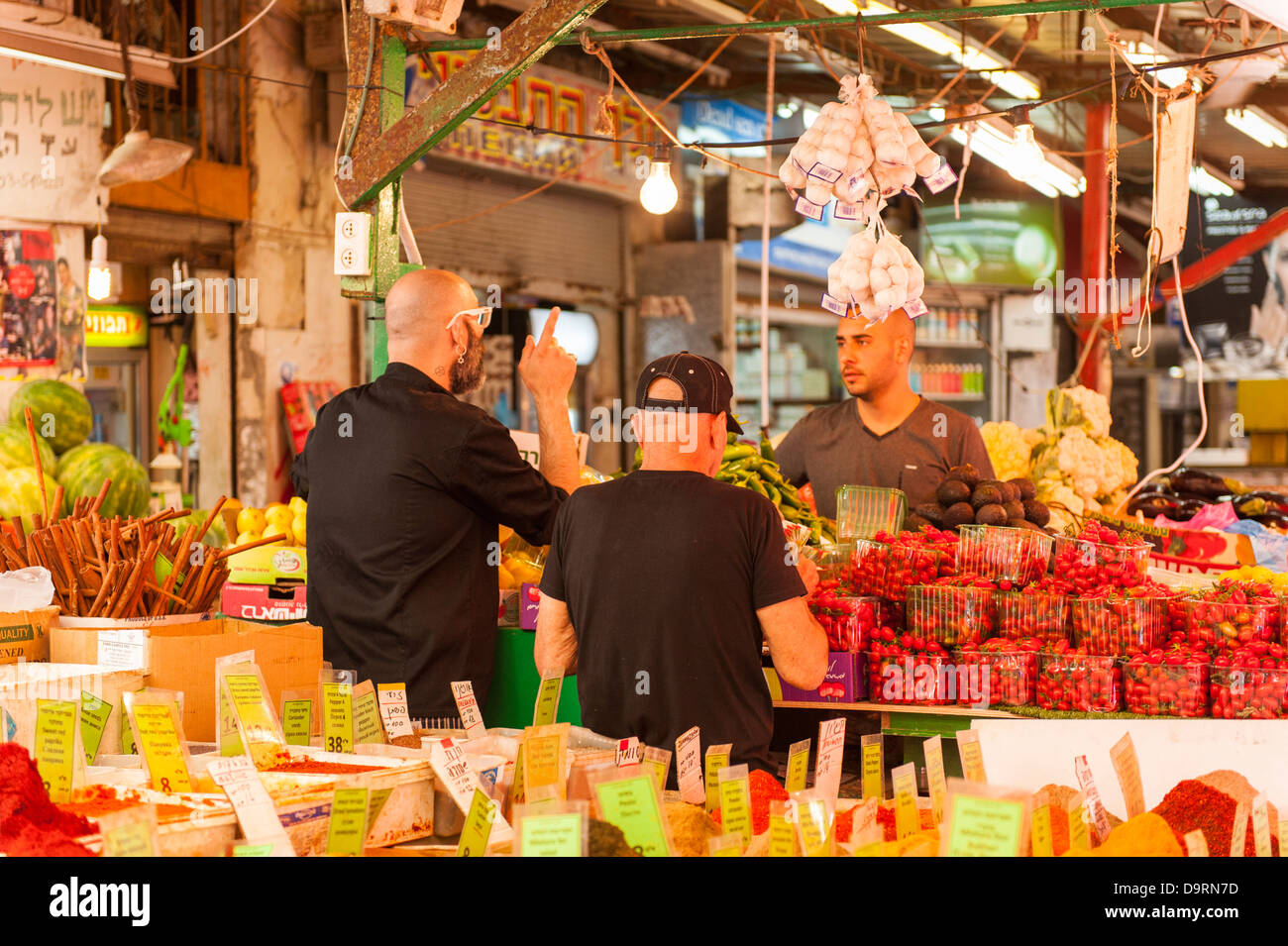 Israel Tel Aviv Carmel Markt Shop Shop verkaufen frische Erdbeeren Erdbeeren Obst Gemüse stall Männer feilschen Preis Auberginen rote Bete chilis Stockfoto