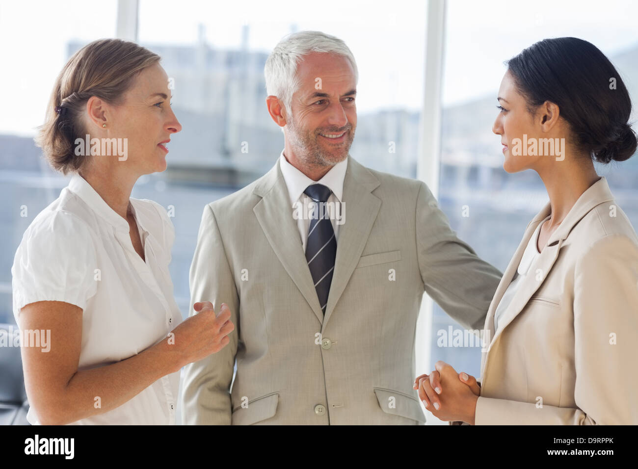 Sympathischer Geschäftsmann mit weiblichen Kollegen sprechen Stockfoto