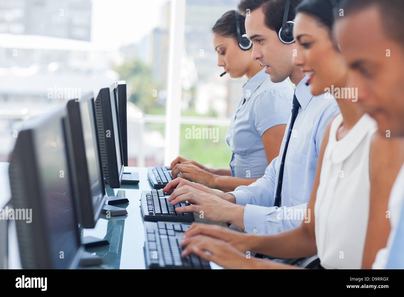 Call-Center-Mitarbeiter arbeiten an Computern Stockfoto