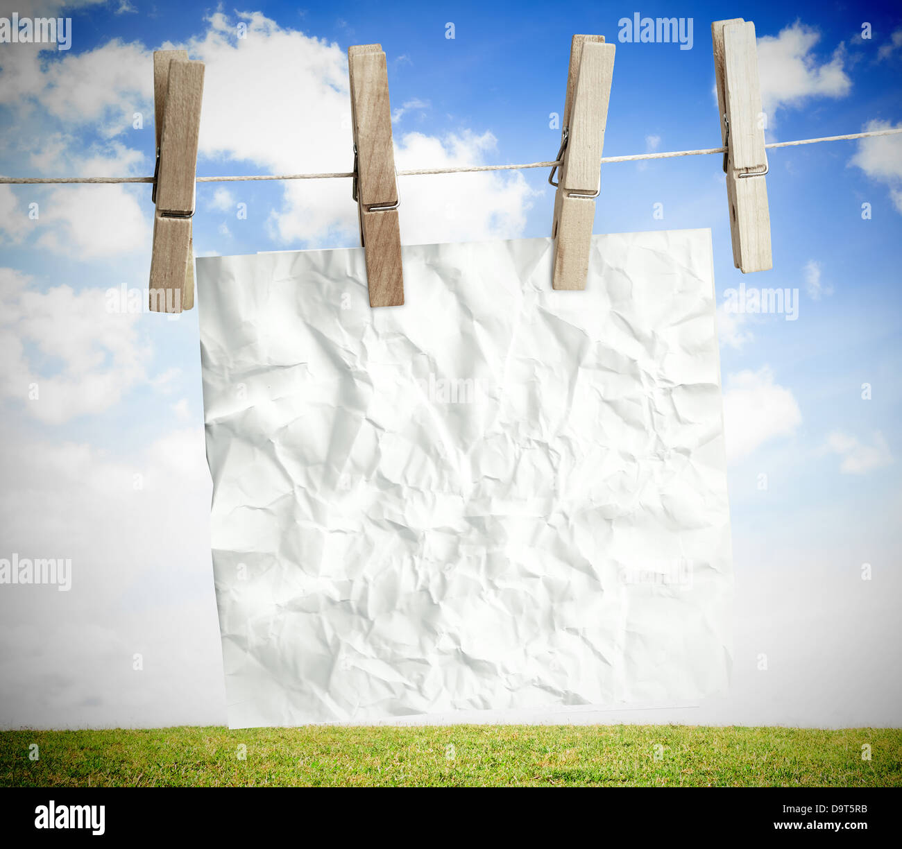 Weiße zerknittertes Papier auf einer Wäscheleine aufgehängt Stockfoto