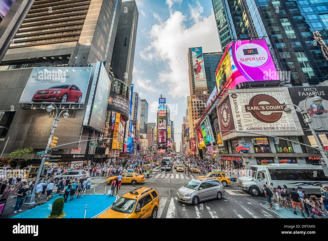Taxis und eine Sightseeing-Busse voller Touristen gehen durch Times Square New York City. Stockfoto