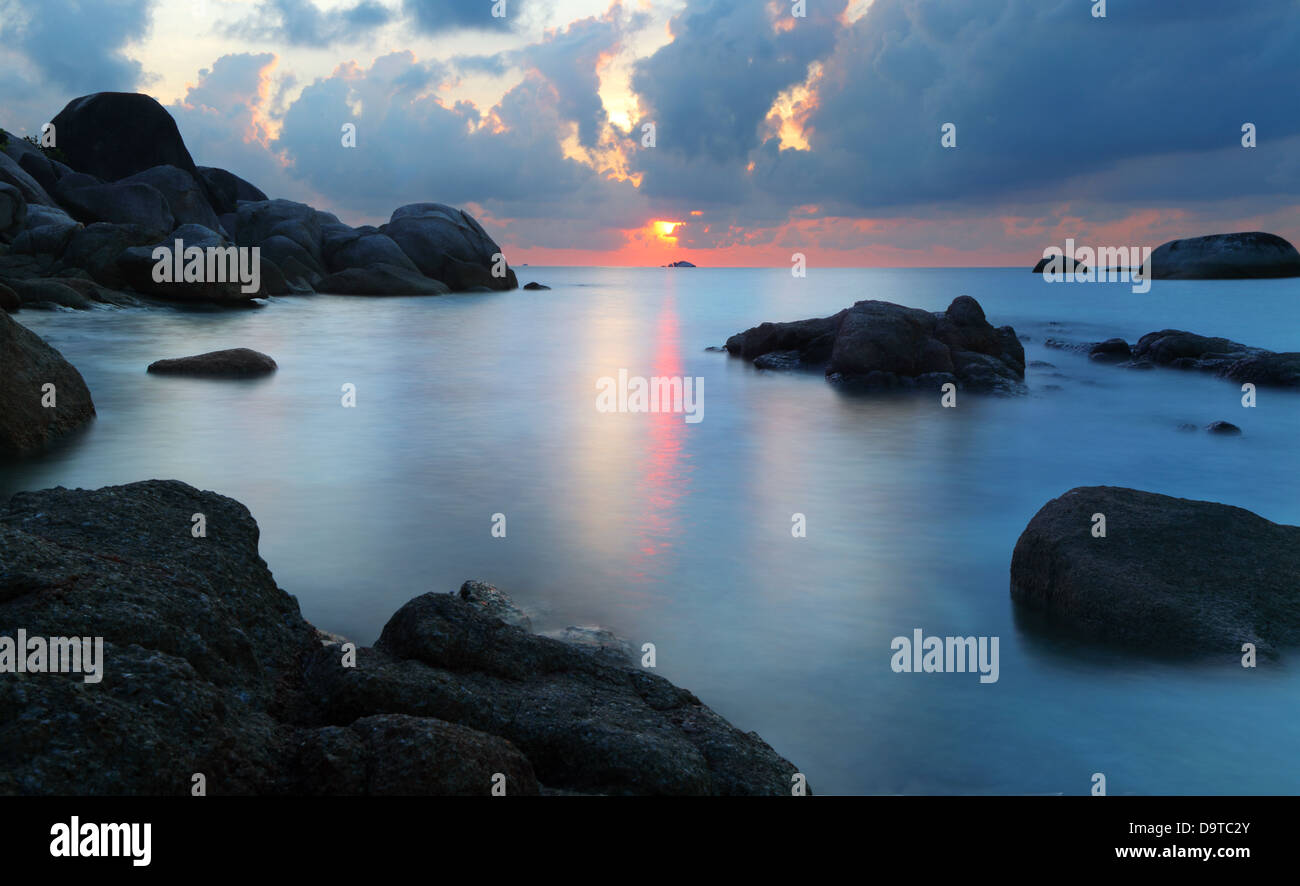 Dramatischer Sonnenuntergang in felsigen Strand, Tanjung Pandan, Belitung, Indonesien. Lange Belichtung geschossen Stockfoto