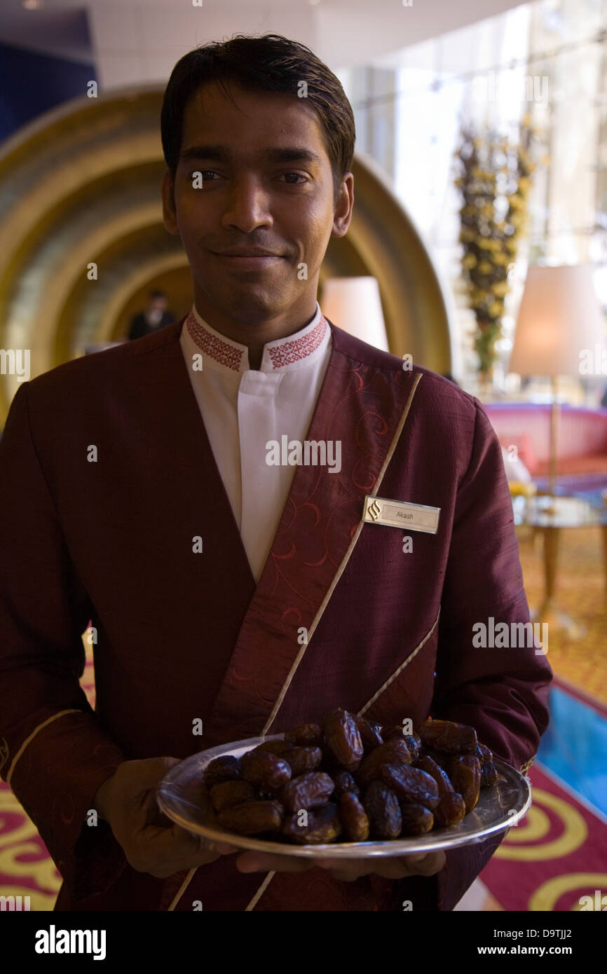 Türsteher auf dem Ultra-luxe Burj al-Arab Hotel Gäste mit einem Tablett mit schmackhaften Datteln, Dubai, U.A.E Stockfoto