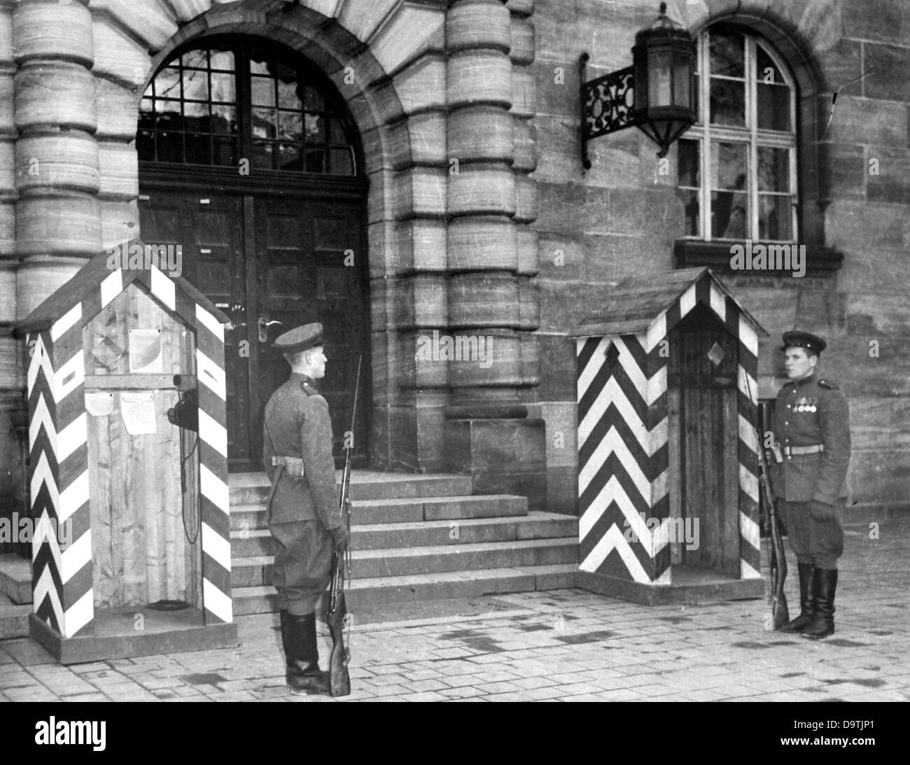 Zwei sowjetische Soldaten bewachen den Eingang des Justizpalastes Nürnberg während der Anhörungen der Nürnberger Prozesse im Zusammenhang mit dem Internationalen Militärgerichtshof gegen die großen Kriegsverbrecher des zweiten Weltkriegs in Nürnberg, 1946. Foto: Jewgeni Chaldei Stockfoto
