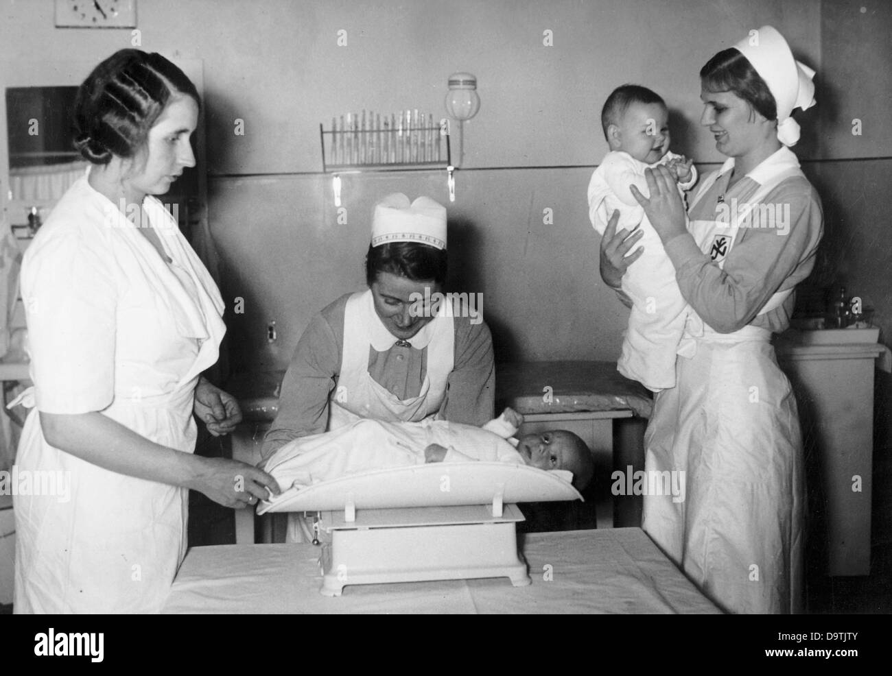 Zwei Krankenschwestern eines Mutter-Baby-Altenheims der Hilfsorganisation „Mutter und Kind“ des National Socialist People's Welfare (NSV) überprüfen die Gesundheit ihrer kleinen Gäste. Fotoarchiv für Zeitgeschichte Stockfoto