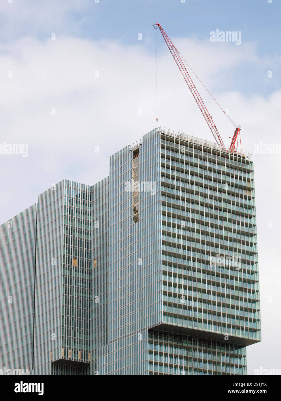 Fast fertig high-Rise Bürohaus in Rotterdam, die Niederlande, mit einem Kran auf dem Dach. Stockfoto