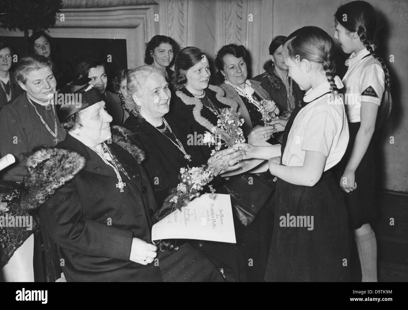 Propagandatext des nationalsozialistischen Berichts auf der Rückseite des Bildes: "Muttertag 1941 in Berlin. Anlässlich des Muttertags 1941 fanden in Berlin individuelle Zeremonien statt, bei denen etwa 3.000 Berliner Mütter mit dem Mutterhonorenkreuz ausgezeichnet wurden. In der Waffenhalle von Schloss Köpenick erfreuen sich die BDM-Mädchen den Müttern nach der Auszeichnung mit frischen Blumen." Bild vom 11. Mai 1941. Fotoarchiv für Zeitgeschichte Stockfoto