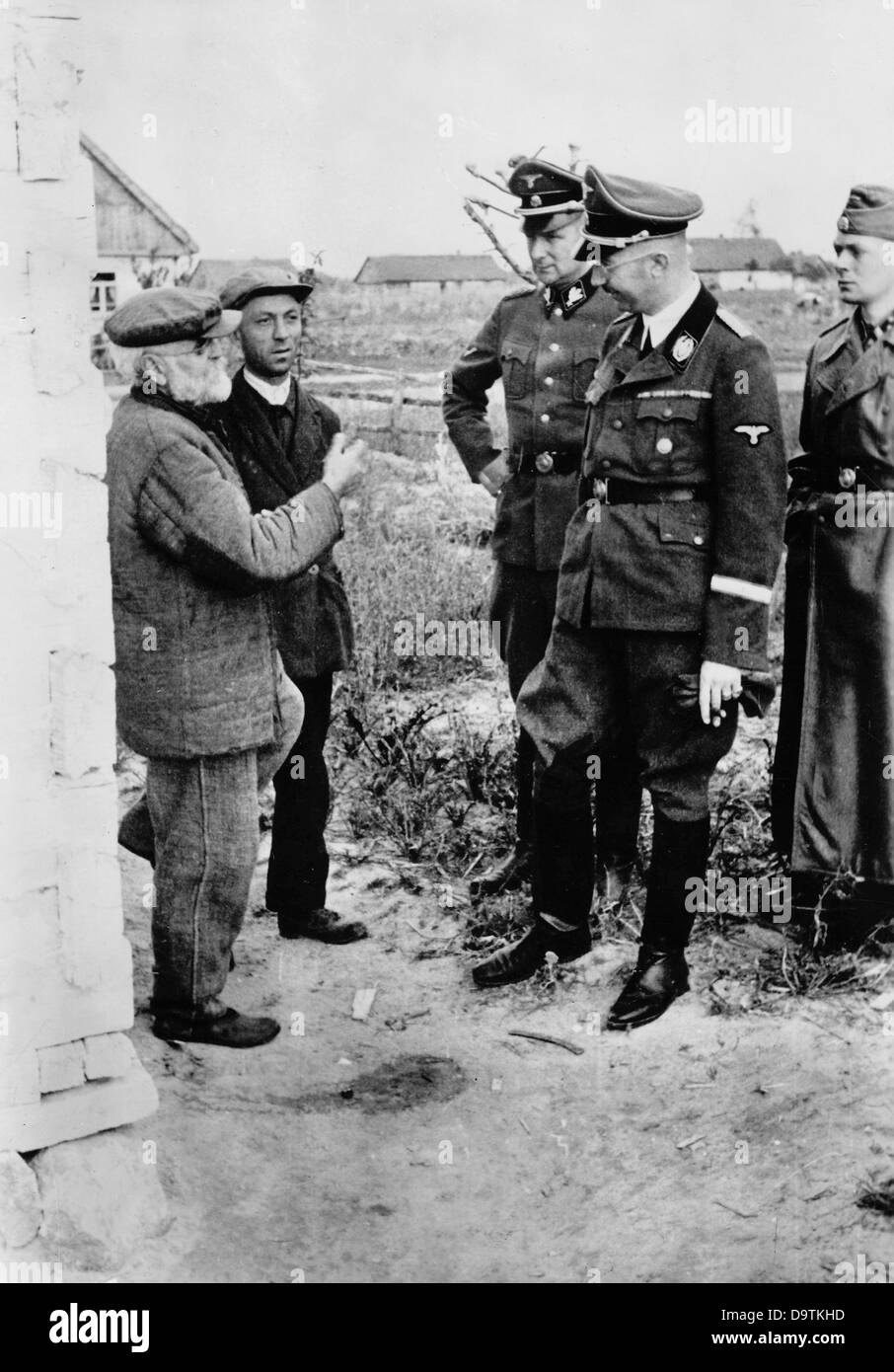 Feldmarschall der SS und Chef der deutschen Polizei, Heinrich Himmler, spricht mit Einheimischen an der Ostfront. Die Nazi-Propaganda! Auf der Rückseite des Bildes ist vom 26. November 1941 datiert: "Reichsführer der SS und Chef der deutschen Polizei Heinrich Himmler unterzog sich einer Inspektion an der Ostfront. In einem deutschen Dorf im sowjetischen Gebiet hielt er an und sprach intensiv mit den Dorfbewohnern über ihr Leid unter dem grauenhaften Joch des Bolschewismus." Fotoarchiv für Zeitgeschichte Stockfoto