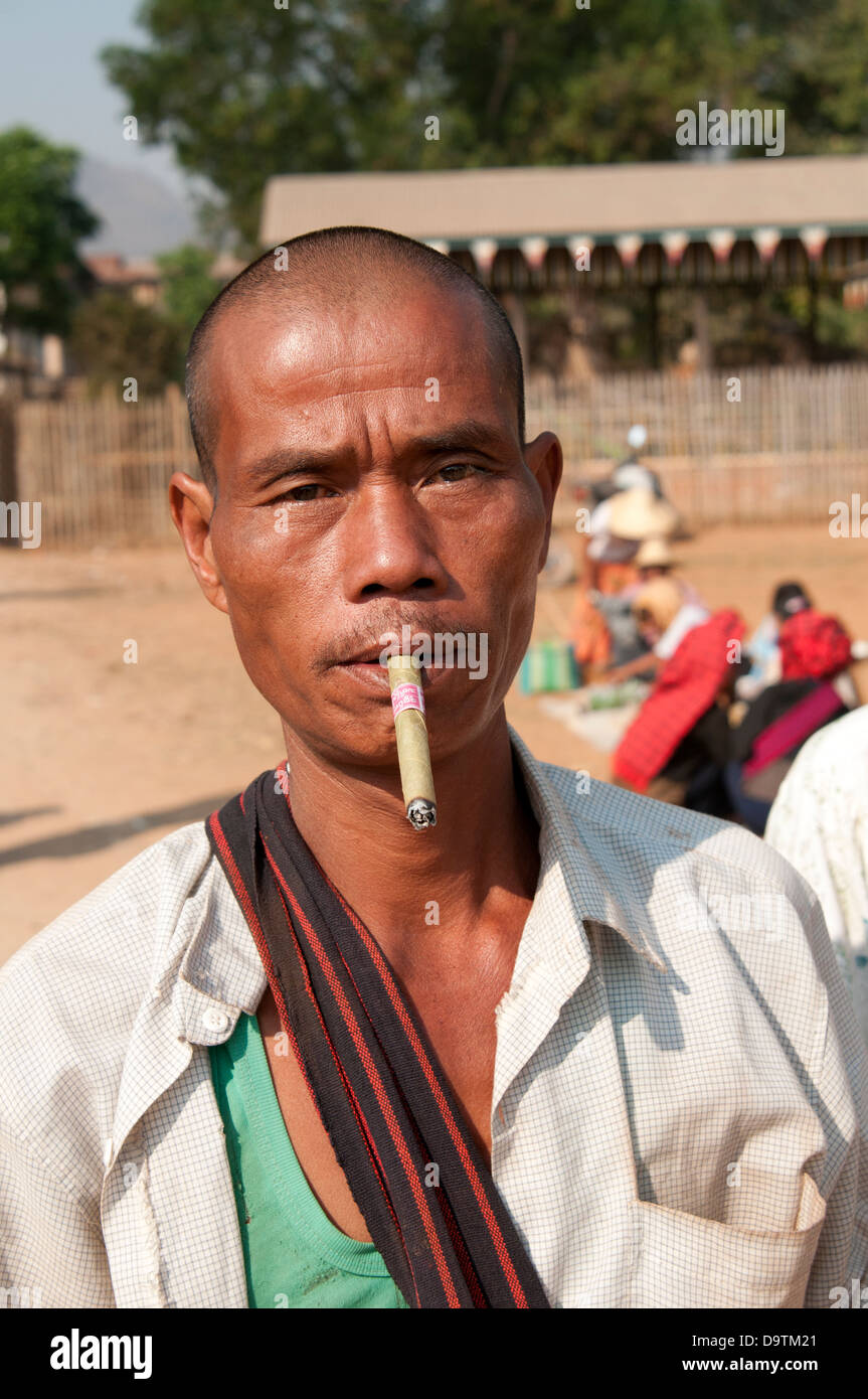 Junge rasierte leitete Intha Mann Rauchen eine Cheroot starrt in die Kamera Inle Lake Myanmar (Burma) Stockfoto