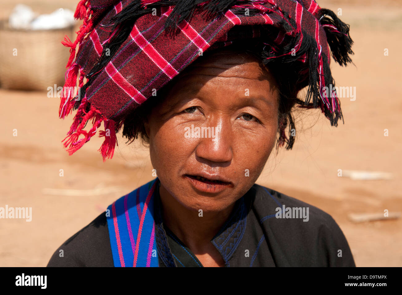 PA-O Frau trägt Orange geprüft traditionelle Kopfbedeckung lächelnd in die Kamera in einem Markt, Myanmar (Burma) Stockfoto