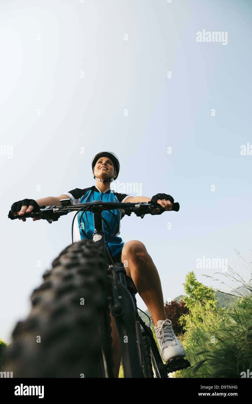 junge Frau training mit Mountainbike und Radfahren im Park. Kopieren Sie Raum, niedrige Winkel Ansicht Stockfoto