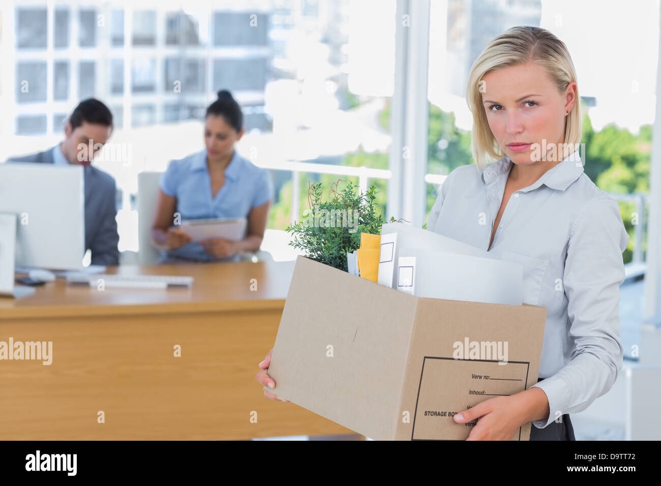 Geschäftsfrau, Ausscheiden aus dem Amt entlassen und Blick in die Kamera Stockfoto