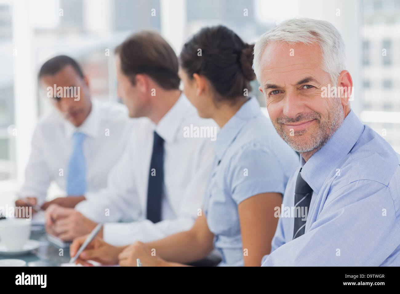 Lächelnde Geschäftsmann posiert im Tagungsraum Stockfoto