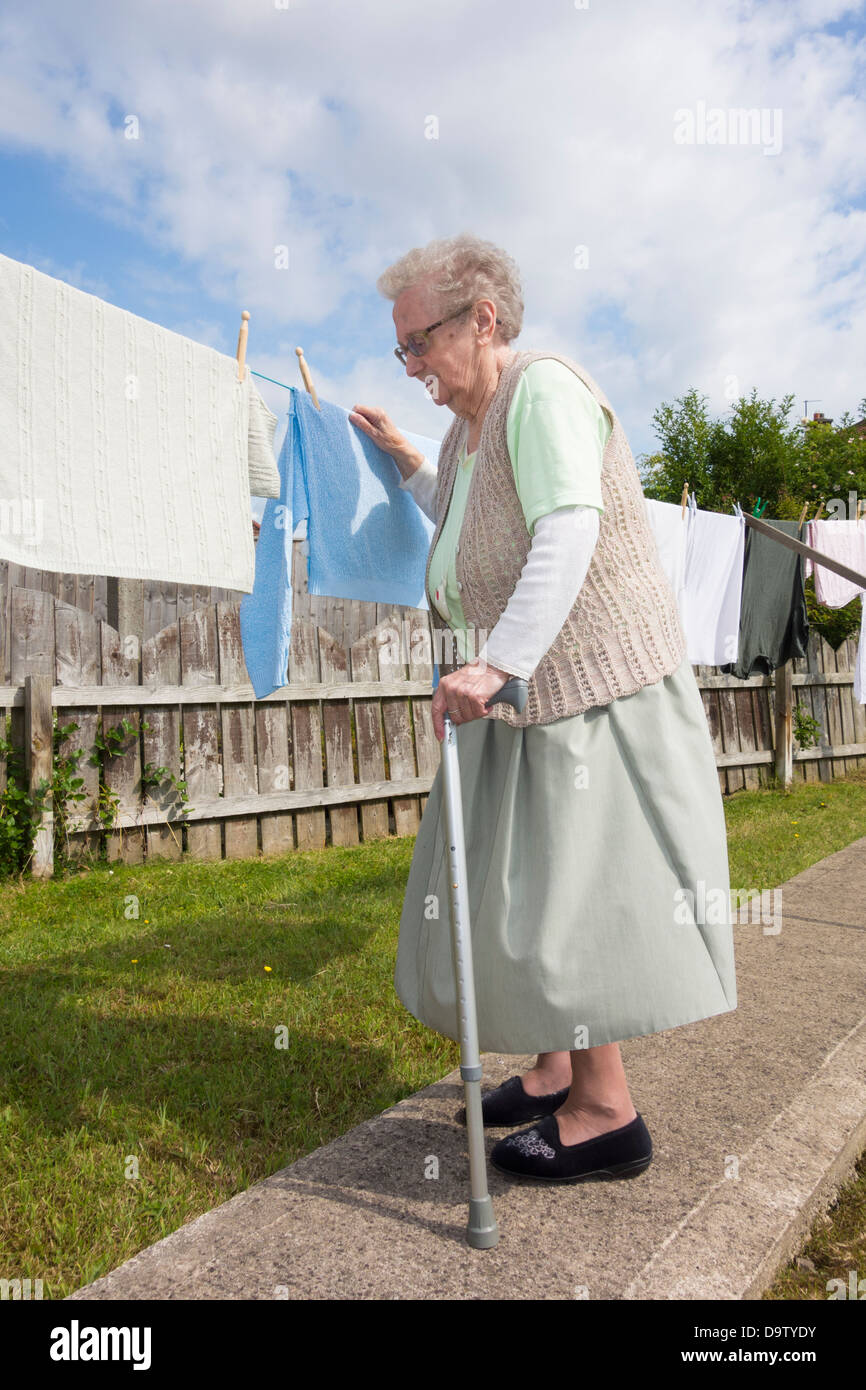 Neunzigjährige Frau, Rentnerin mit Walking/zimmer-frame-überprüfung, Wäsche online. GROSSBRITANNIEN Stockfoto