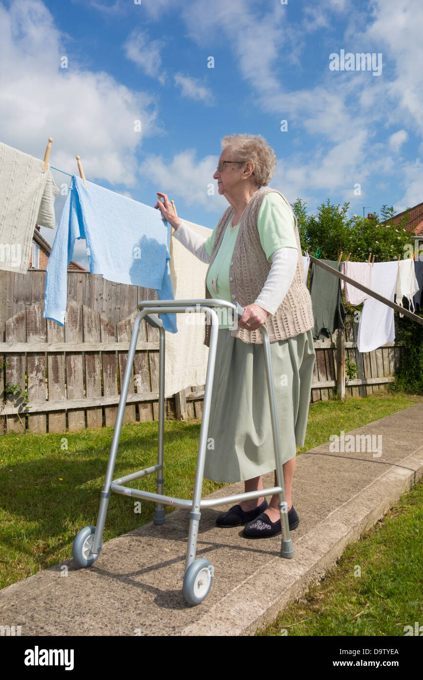 Neunzigjährige Frau, Rentnerin mit Walking/zimmer-frame-überprüfung, Wäsche online. GROSSBRITANNIEN Stockfoto