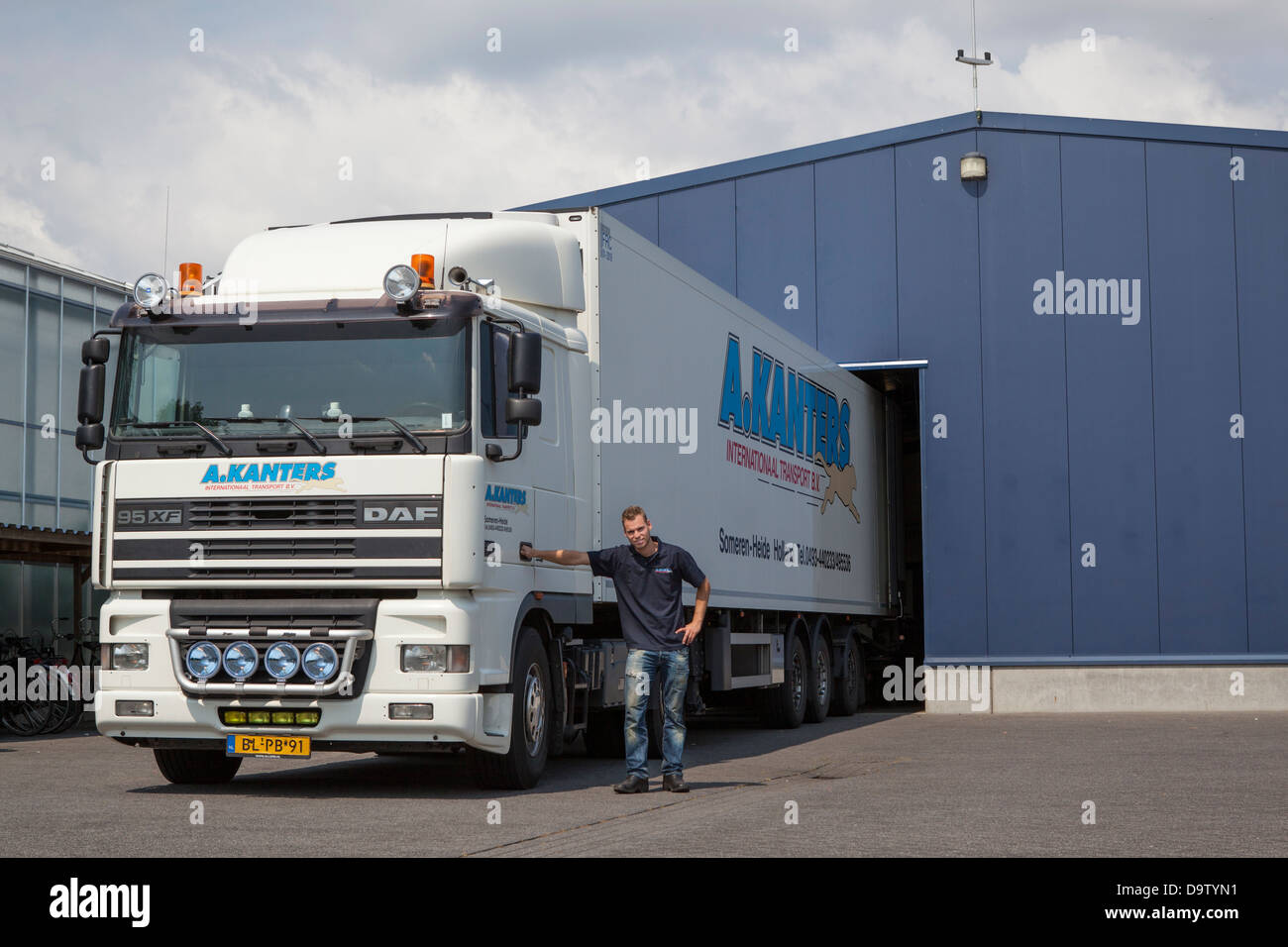 LKW-Fahrer und DAF XF LKW vor einem Dock in den Niederlanden Stockfoto