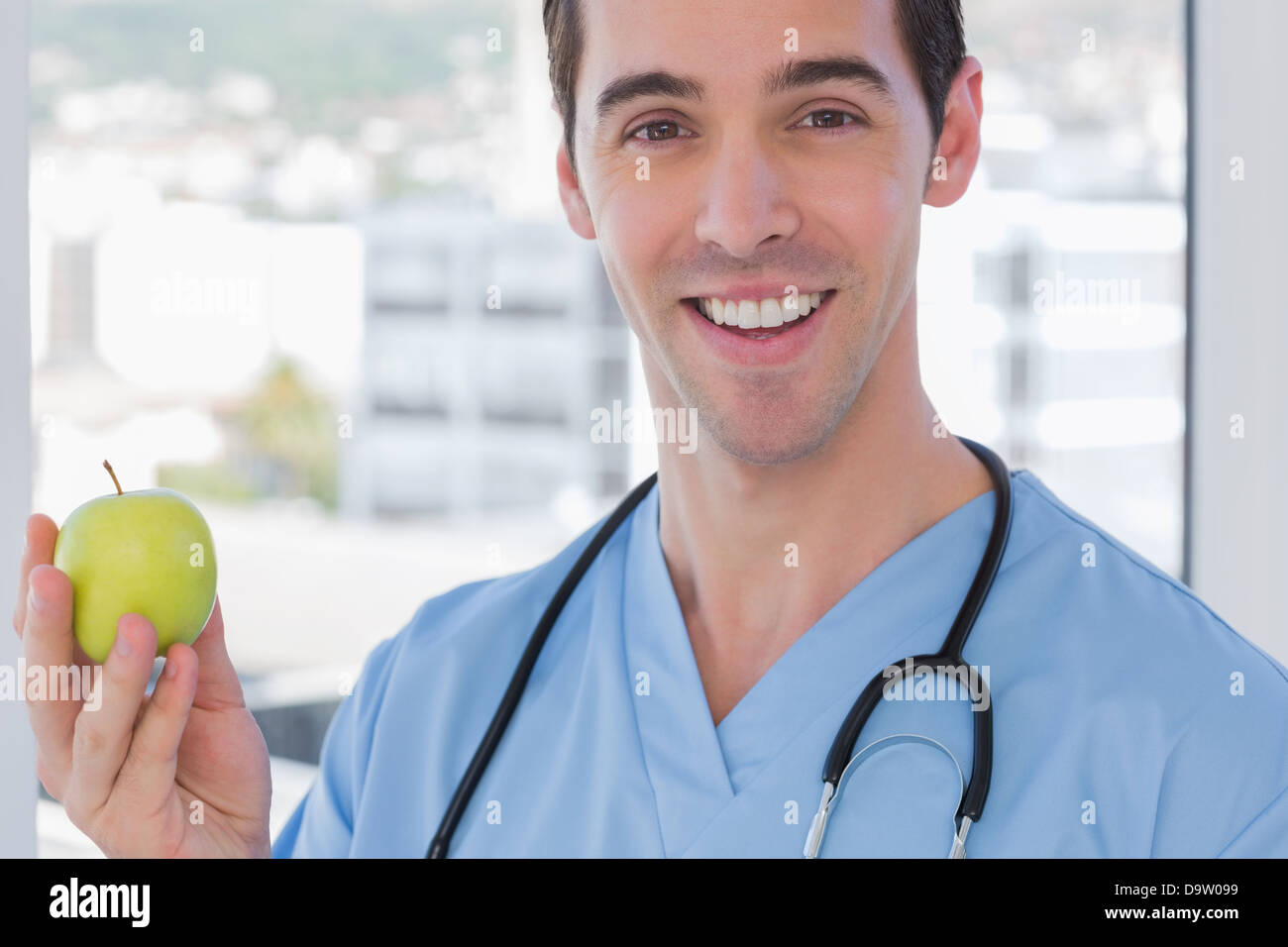Praktiker hält einen grünen Apfel Stockfoto
