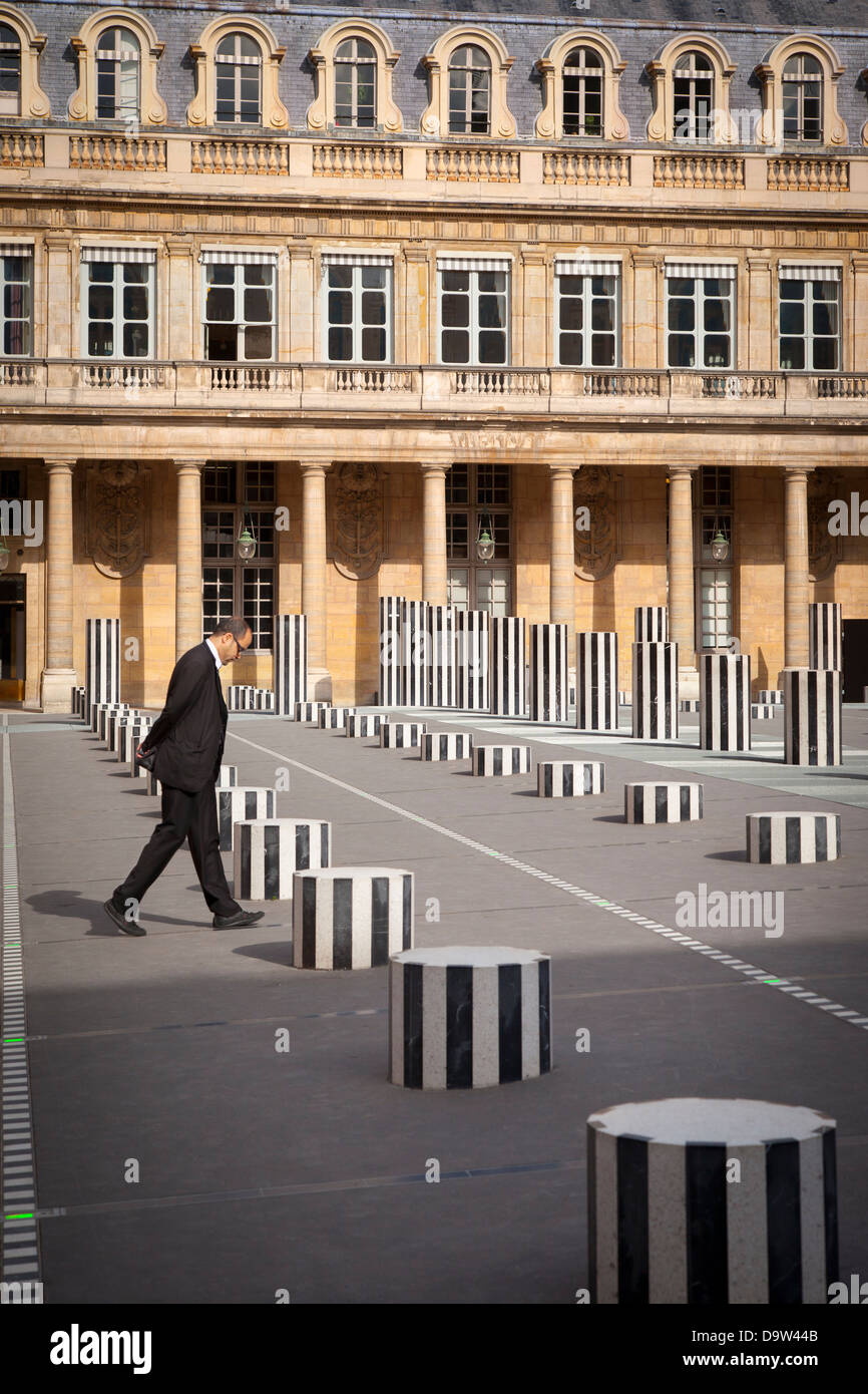 Mann im Anzug geht über den Hof des Palais Royal, mit Daniel Buren erstellte Spalten, Paris Frankreich Stockfoto