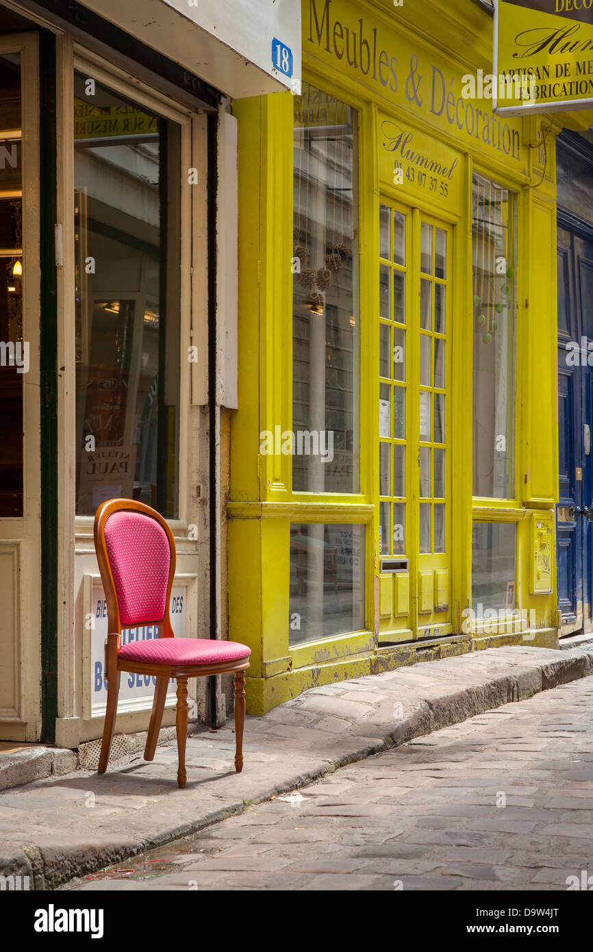 Rosa Stuhl vor Möbel speichert entlang Chantier Passage in der Nähe von Bastille, Paris Frankreich Stockfoto